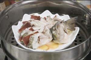 將鱸魚成花狀擺好，將火腿切片放入各縫隙中，放入鍋中隔水蒸12分鐘拿出，撒上蔥花即可。