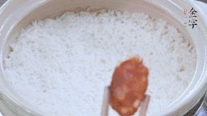 煮開后轉小火，當米飯出現(xiàn)小孔時，鋪上金字麻辣香腸。