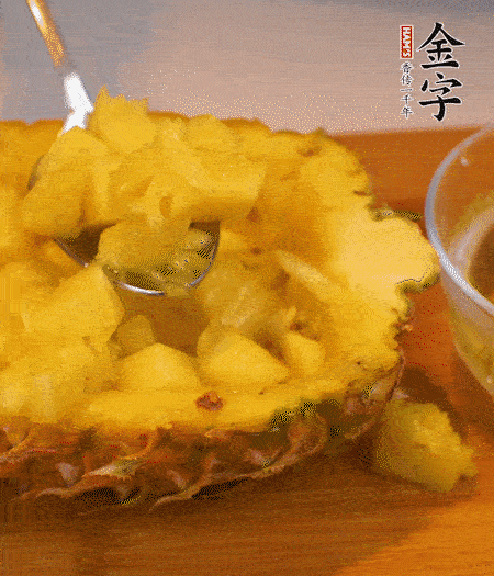 菠蘿對(duì)半切開，切成小方格，用勺子把菠蘿肉挖出來(lái)。用鹽水稍浸泡。
