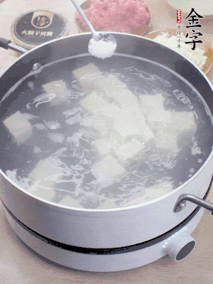 豆腐切成大小均勻正方體，鍋內(nèi)放水，加一點鹽焯水10秒。
