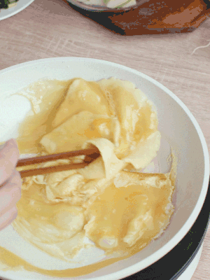 油6成熱時，下雞蛋液，邊緣凝固時翻拌成塊狀。
