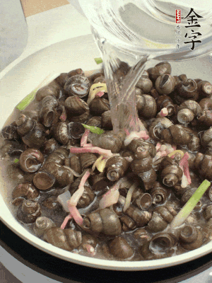 倒處理干凈的螺螄翻炒，加3勺料酒。加清水蓋過(guò)螺螄，中火蓋蓋煮5分鐘。
