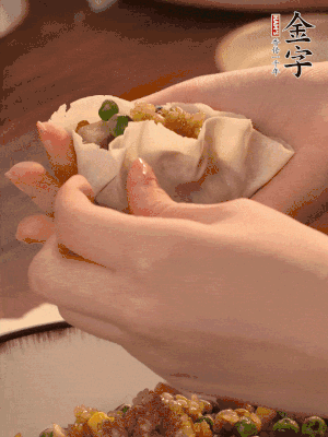 取一大勺餡料放進(jìn)餃子皮里，用大拇指按住頂部餡料，再用虎口掐出形狀。