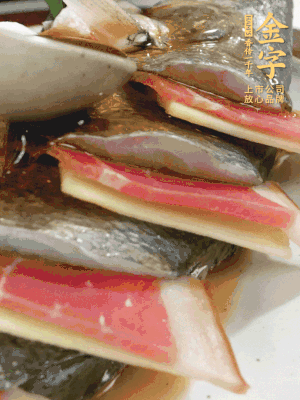 魚肚中塞蔥結、火腿片，魚身上碼放姜片、火腿片，倒入混合的料汁。