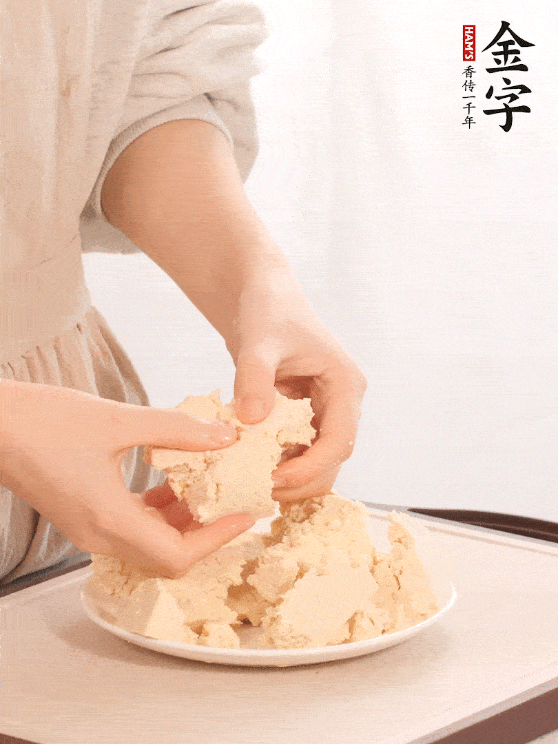 老豆腐用手掰成塊。